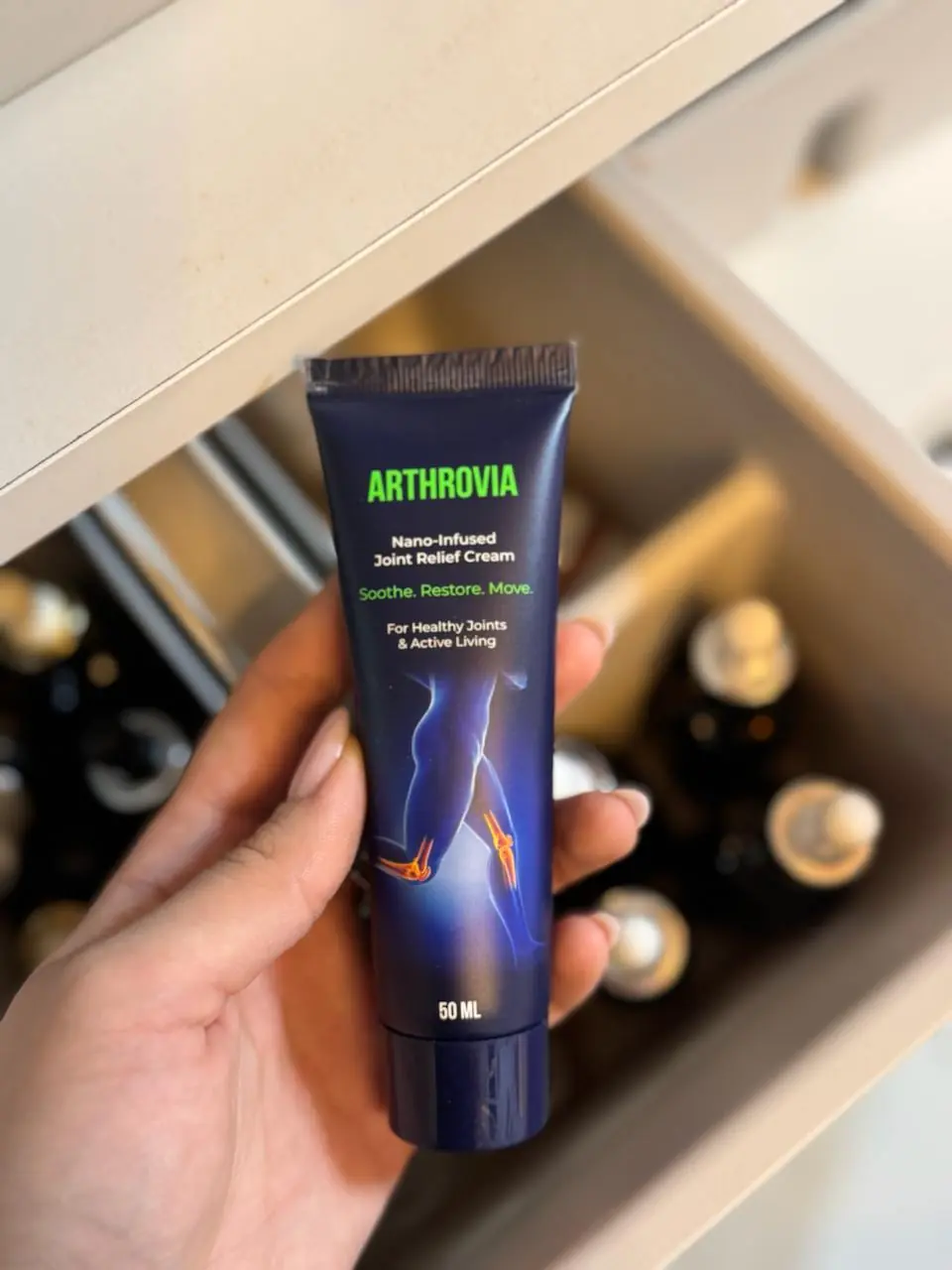 Tuba Arthrovia 50 ml v roki: zelen napis ARTHROVIA in slogan Soothe. Restore. Move.